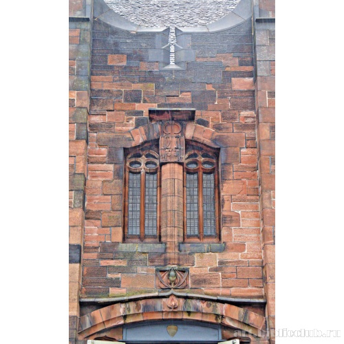 Фрагмент стены с разноцветной кладкой, неоготическим окном и скульптурным декором